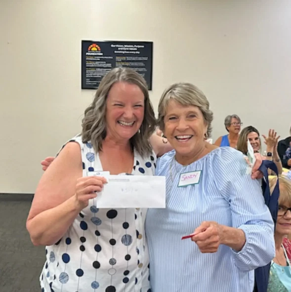 Music Trivia Bingo 50/50 raffle winner Sandy Tedeschi presented a check by Gina Ogle at the Sun City West Foundation event.