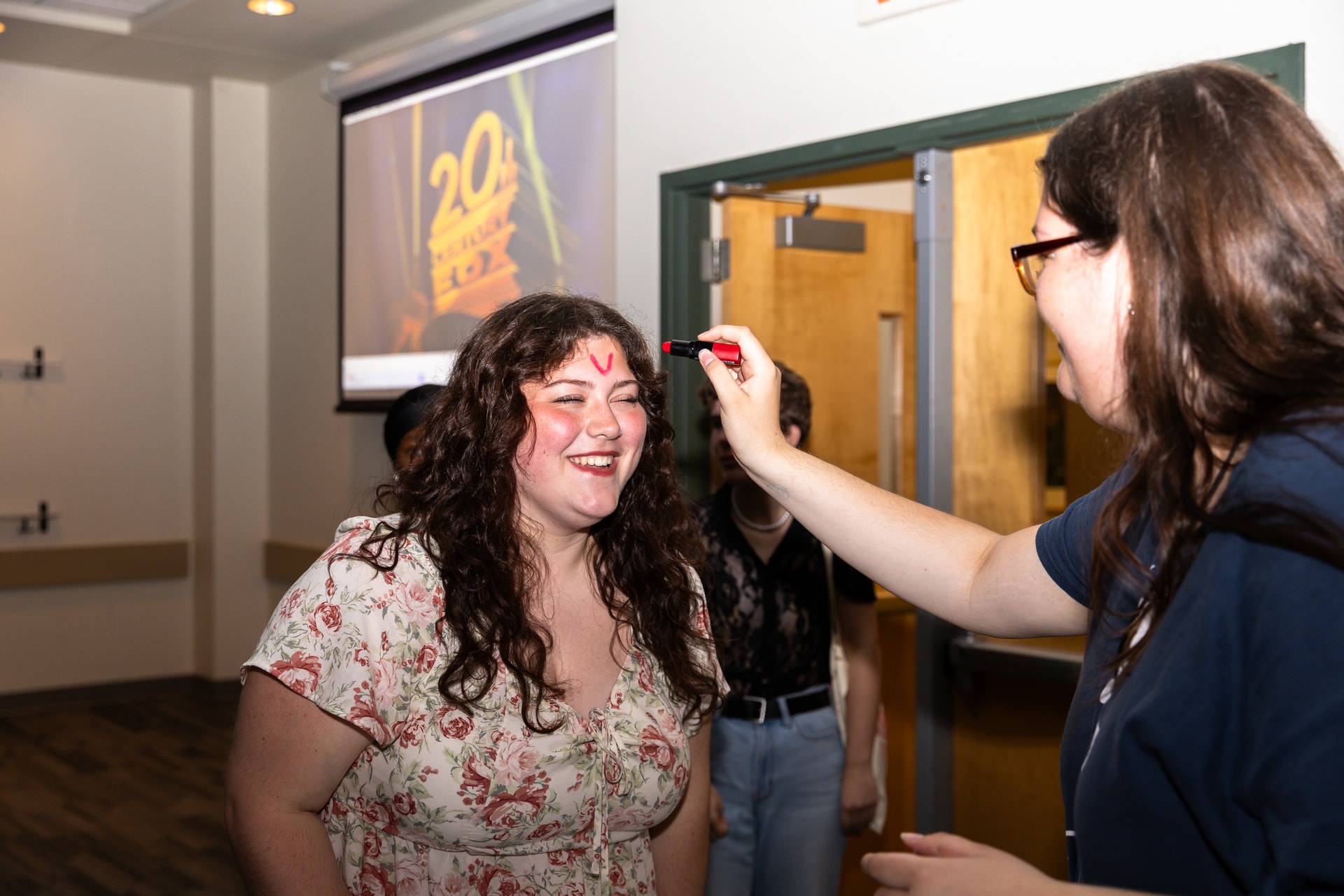 Student getting "V" drawn on forehead
